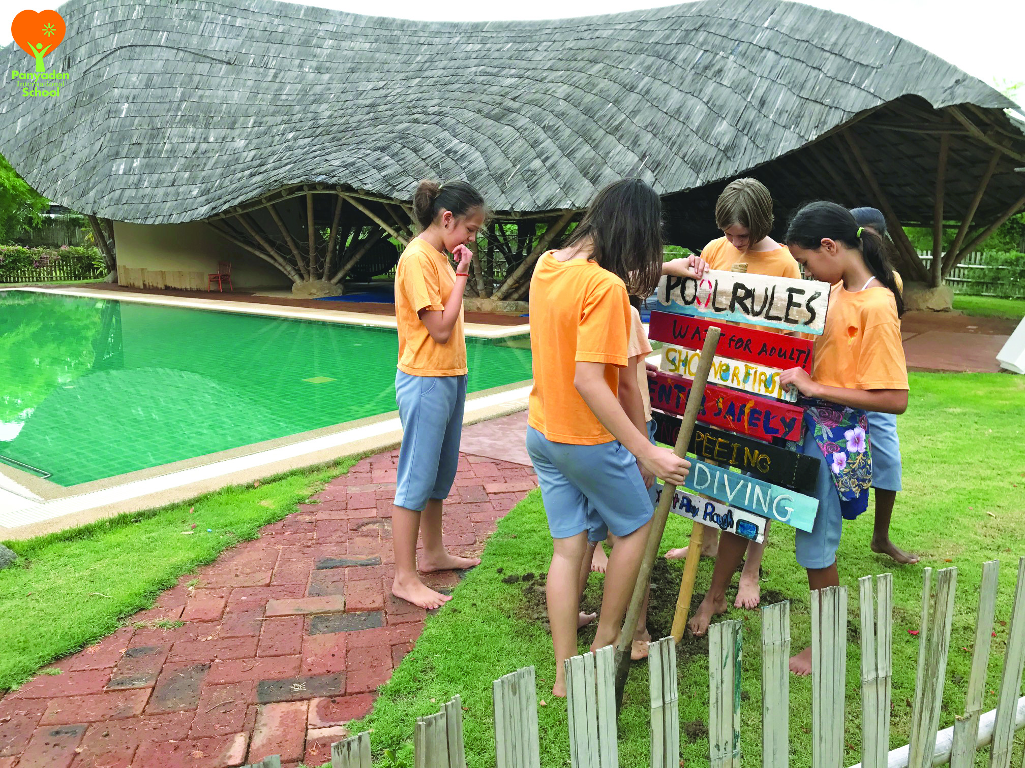 Panyaden Year 6/7 students putting up the wooden swimming pool rules signboards they made