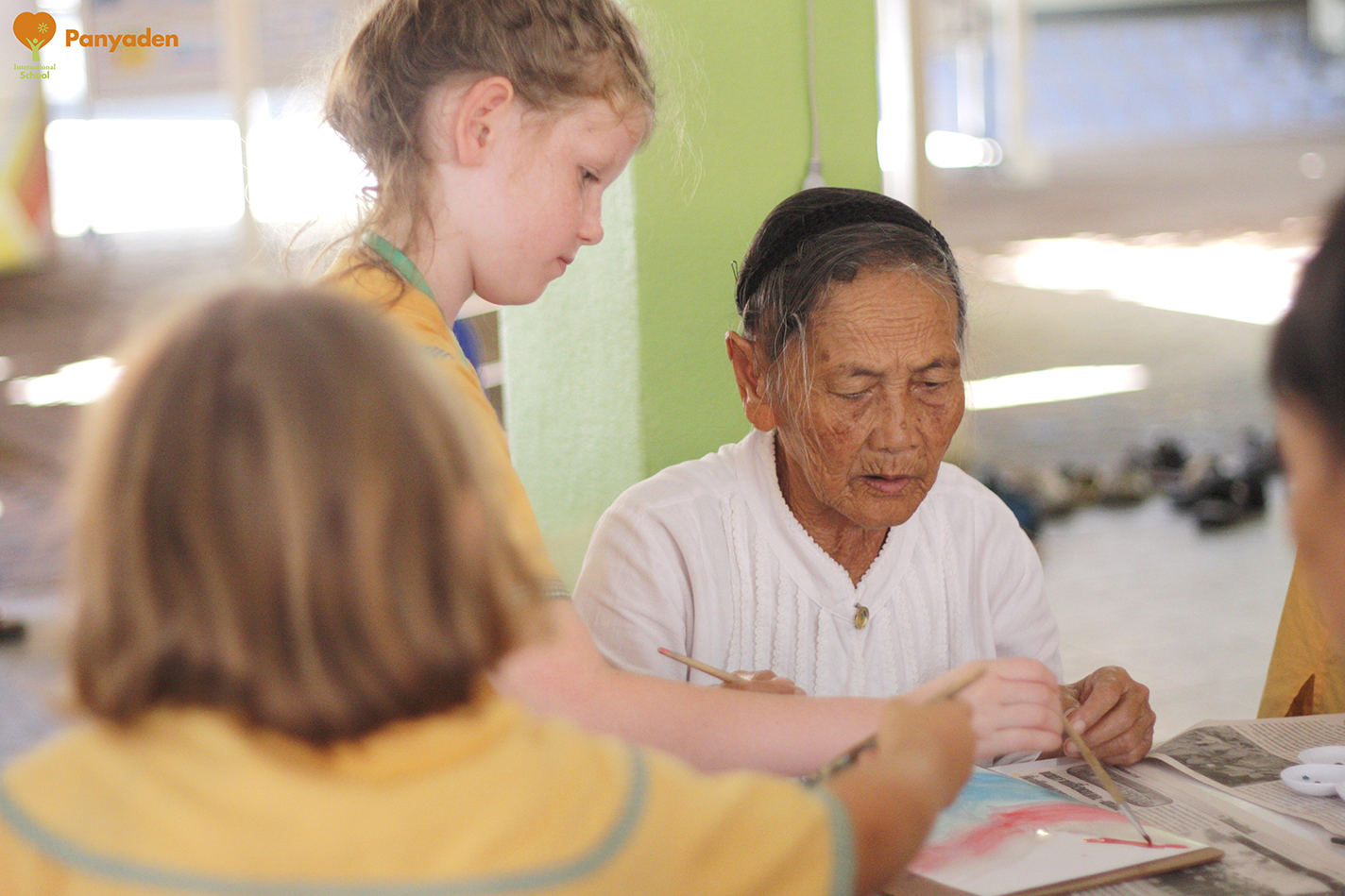 Panyaden Social Contribution Day: Panyaden student painting with resident at elder aId home in Chiang Mai